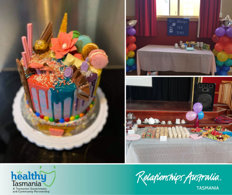 A very colourful and extravagant cake sits on table with healthy snacks and tea.