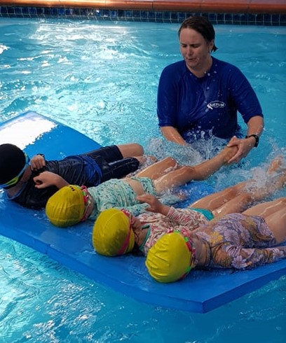  Phoenix Community House project co-ordinator Beth Rosser with swim class - kids kicking in the pool